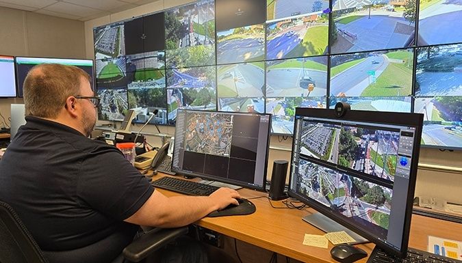 Operatör övervakar kamerabilder på flera skärmar i ett kontrollrum
