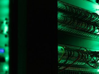 Serverrack med tätt anslutna nätverkskablar i grönt ljus